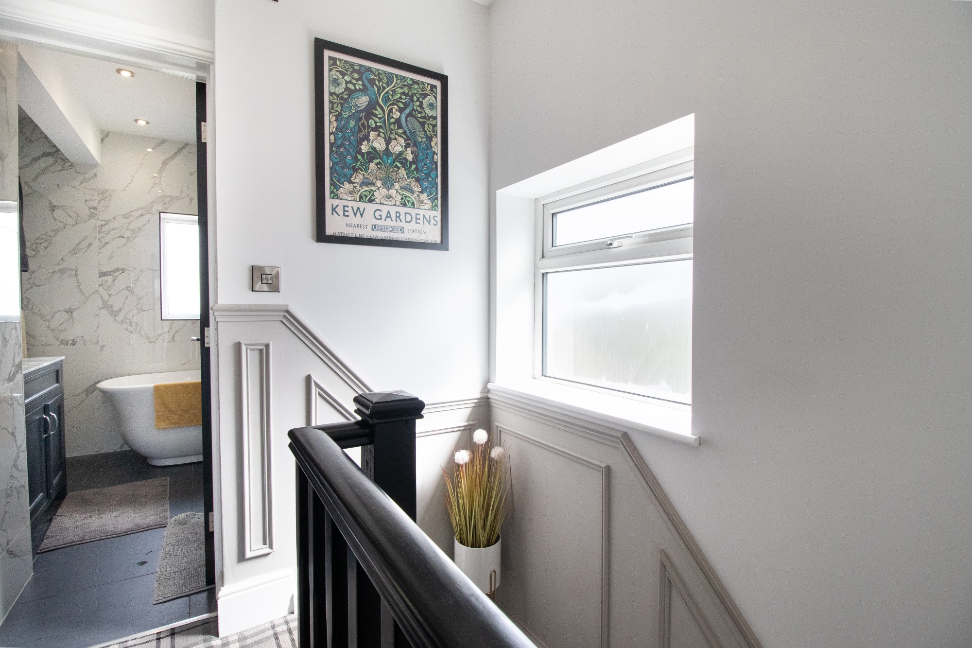 Landing at the top of stairs with an open door to a bathroom